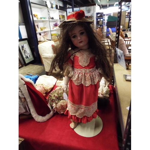 498 - A vintage 24” German bisque head doll in period outfit (not original costume) on metal stand