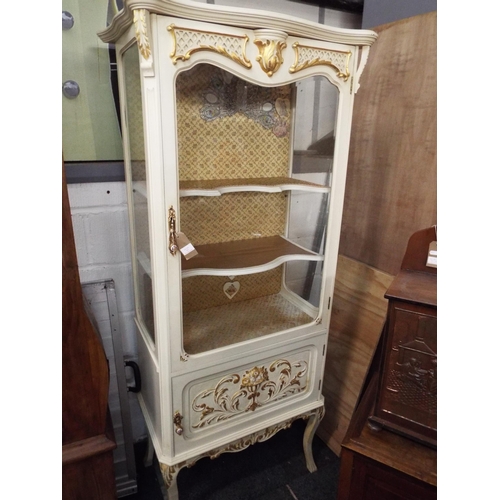 513 - A vintage glass display cabinet having glazed door with two shelves above a cupboard resting on cabr... 