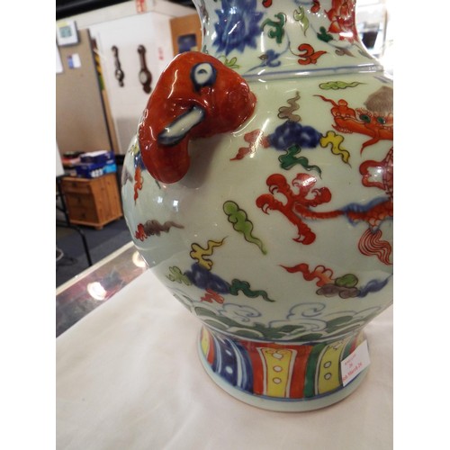 26 - A Chinese Ming vase decorated with a dragon chasing a pearl of wisdom, elephant mask handles signed ... 