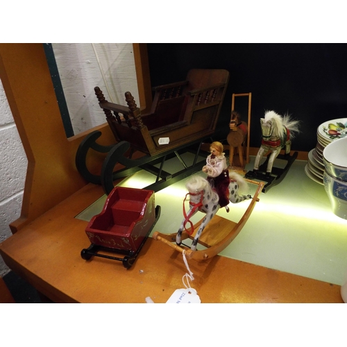 91 - A small selection of wooden dolls house furniture to include rocking horses and sleighs
