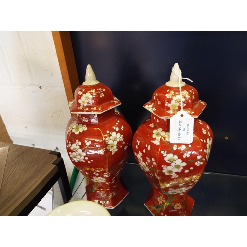 98 - A pair of Oriental vases of a brown/red colour decorated with prunus with lids 12