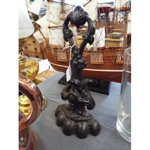 335 - A black painted cast iron door stop having floral decoration