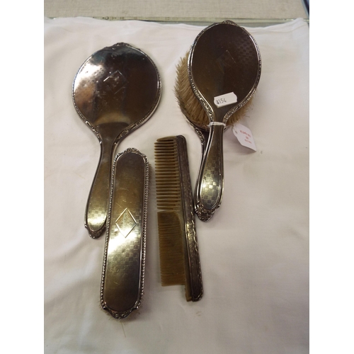 183 - A Birmingham 1923 silver dressing table set comprising of mirror, brushed, comb and clothes brush