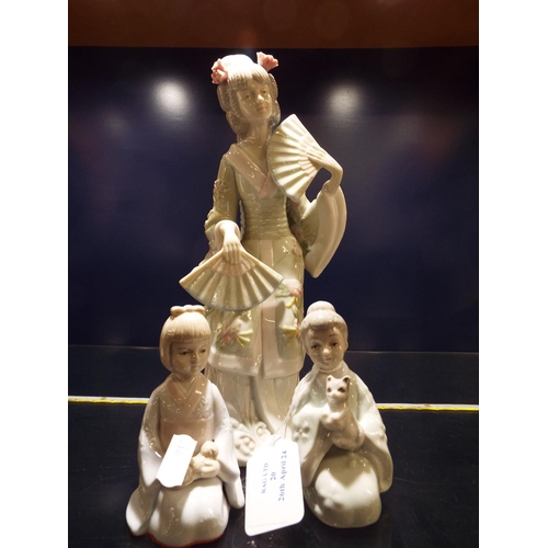 20 - An Oriental figurine of a female with fans together with two kneeling children