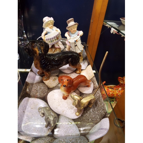 48 - Two creamware fairings together with a selection of dachshund china and metal figurines to include a... 