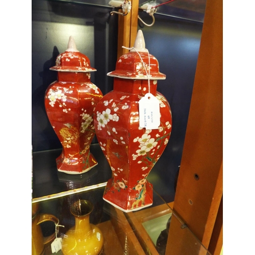 69 - A pair of Oriental vases of a brown/red colour decorated with prunus with lids 12