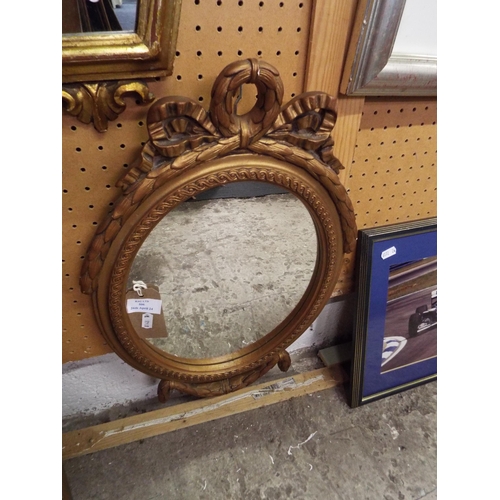 506 - An oval framed wall mirror with moulded decoration