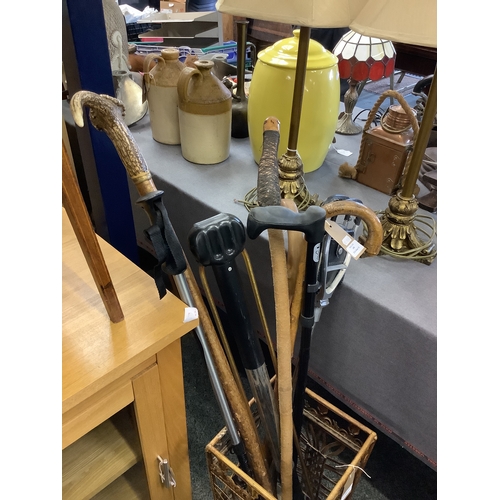 498 - A mixed selection of assorted walking sticks and walking aids to include a horn handle example, one ... 