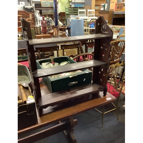 514 - A mahogany hanging three shelf unit with pierced sides