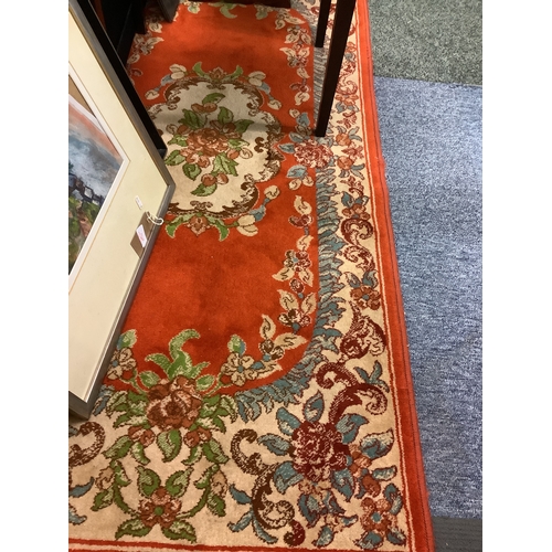 521 - A small good quality orange and blue ground rug with floral decoration, made in Israel 29