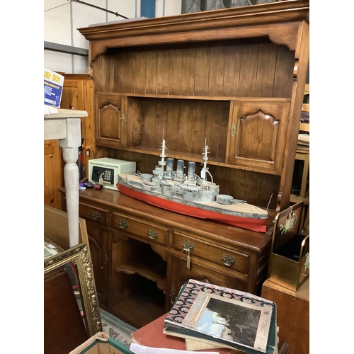 638 - A large oak dresser the top having two plate racks with small cupboards above three short drawers wi... 