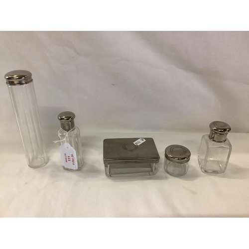 111 - A group of five white metal top dressing table bottles