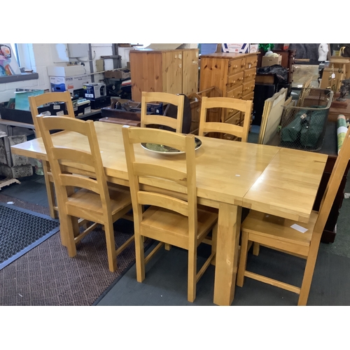 577 - A beech drop leaf oblong kitchen table and a set of six ladder back chairs