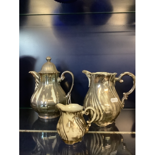 56 - A silver painted china tea-pot, milk jug and cream jug