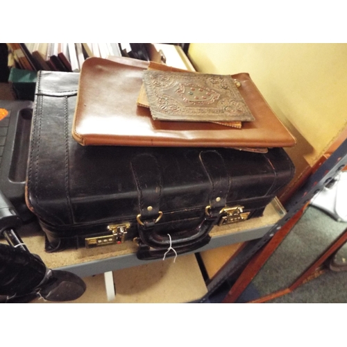 434 - A vintage black leather briefcase and four leather covers