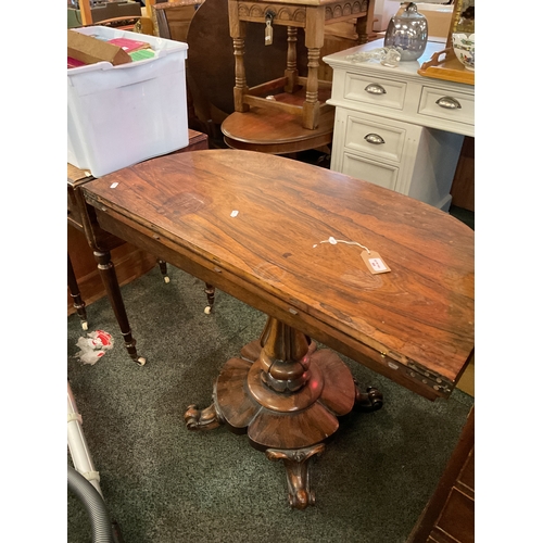 506 - An early Victorian rosewood tea table with fold over leaf resting on carved pedestal and scroll supp... 