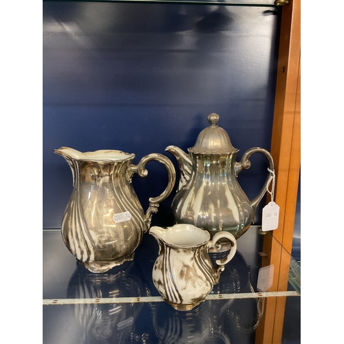 50 - A silver painted china tea-pot, milk jug and cream jug