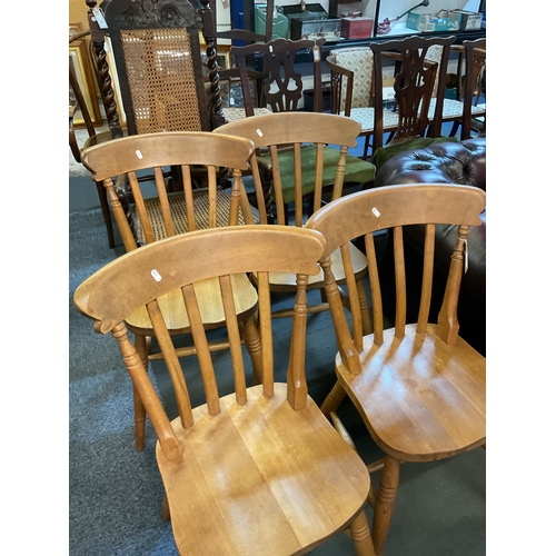 403 - A set of four pine rail back dining chairs