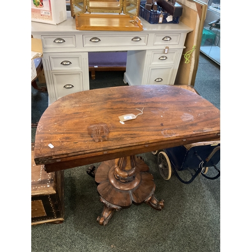 528 - An early Victorian rosewood tea table with fold over leaf resting on carved pedestal and scroll supp... 