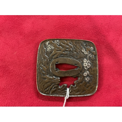 262 - A Japanese bronze Tsuba with inlaid silver decoration