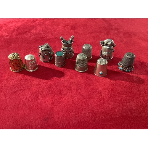 251 - A mixed selection of thimbles to include three silver examples