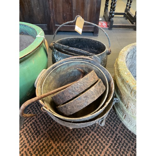 570 - A cast iron cauldron, pair of cart wheels and five metal pots