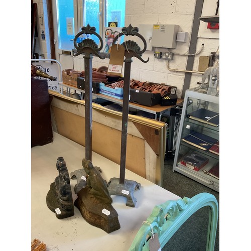 617 - Two cast iron doorstops and a pair of copper fire iron stands