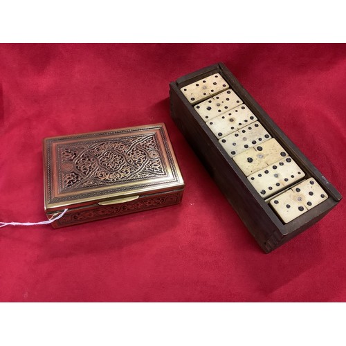 190 - A vintage brass cigarette box finely engraved with a floral pattern together with a set of bone domi... 