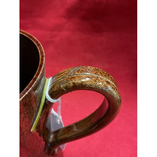 55 - A Sussex art ware Rye Pottery tankard with applied hop and vine decoration (repair to handle)
