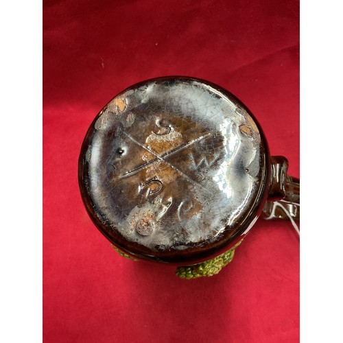 55 - A Sussex art ware Rye Pottery tankard with applied hop and vine decoration (repair to handle)