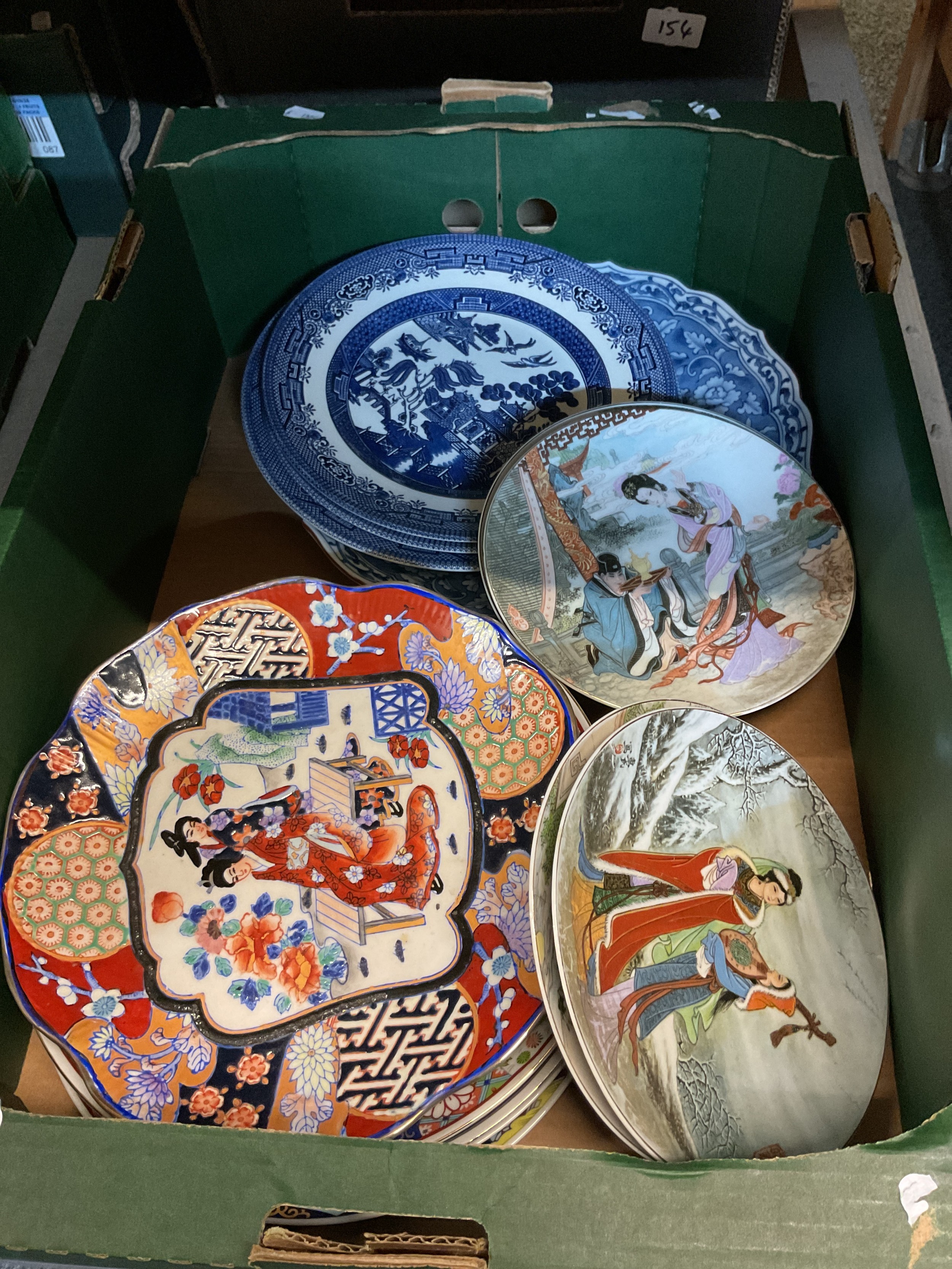 A box of assorted plates to include blue and white and Oriental examples