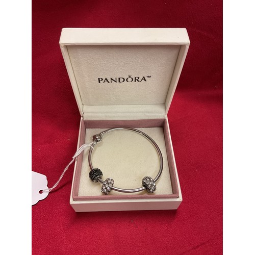 A boxed sterling silver Pandora bracelet and three charms
