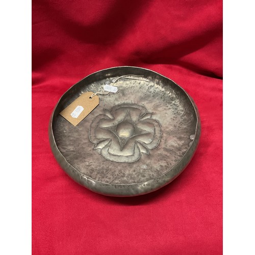 95 - An Arts & Crafts pewter bowl with internal hand beaten flower design standing on three feet