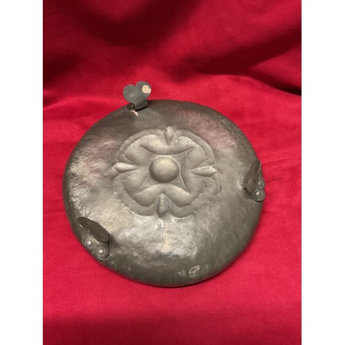 95 - An Arts & Crafts pewter bowl with internal hand beaten flower design standing on three feet