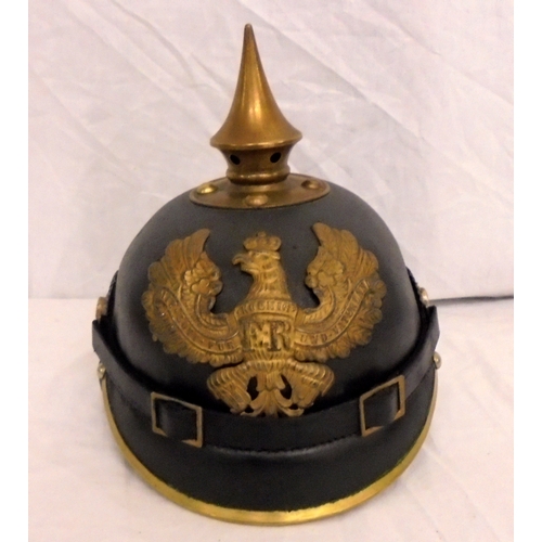 225 - C19th German Pickelhaube with central spike, trimmed visor, spread eagle insignia with FR Koenig