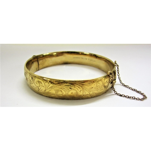 488 - 9ct. Gold Metal Cored Hinged Bangle with engraved decoration