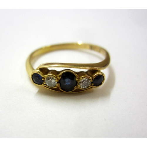 218 - 18ct. Gold Sapphire & Diamond Ring in cross over setting, central oval sapphire with circular sapphi... 