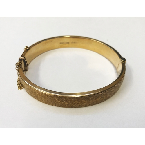 249 - 9ct Gold Half Hinged Bangle, textured finish, safety chain