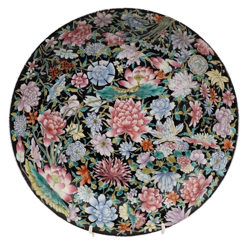 1141 - A Chinese famille noire millefleurs charger: painted with lotus, peony, chrysanthemum and other bloo... 