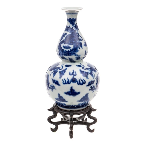 1174 - A Chinese blue and white double gourd 'Dragon' vase: painted overall with dragons chased flaming pea... 