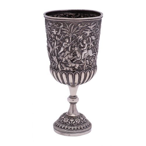 809 - An Indian silver cup: the bowl with embossed hunting scene and half reeded decoration, on a knopped ... 