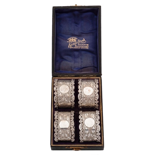 812 - A set of four Edwardian silver napkin rings, maker Kemp Brothers, Birmingham, 1904: with scroll and ... 