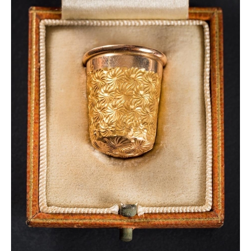 988 - A 15ct gold thimble: with foliate decoration, stamped '7', approximately 5.5gms gross weight togethe... 