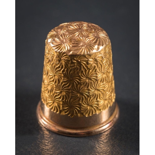 988 - A 15ct gold thimble: with foliate decoration, stamped '7', approximately 5.5gms gross weight togethe... 