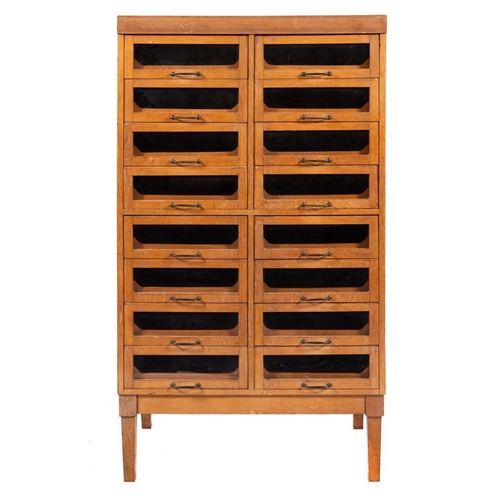 312 - A mid 20th Century beech haberdashery cabinet:, of two flights of eight glazed drawers, enclosing sl... 