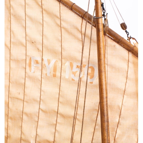 245 - A scale model of the Mevagissey Lugger FY150 'Margaret' by D Proctor: fully rigged above open deck w... 