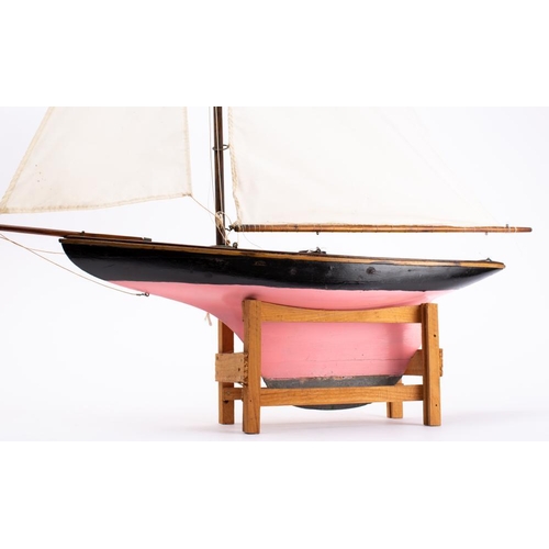 251 - An early 20th century pond yacht: fully rigged over  simulated plank deck, the hull painted black to... 