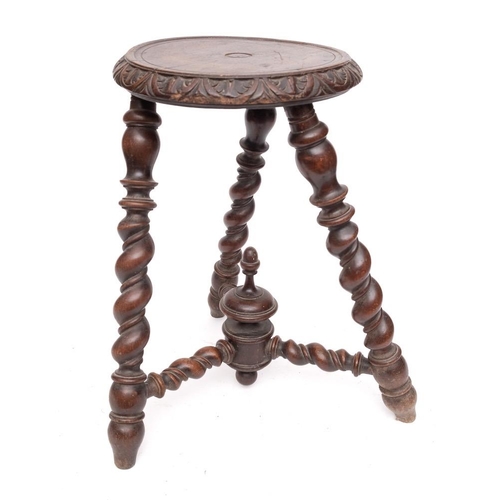 11 - A 19th Century turned beechwood milking stool:, the circular seat with lunette foliate carved edge, ... 