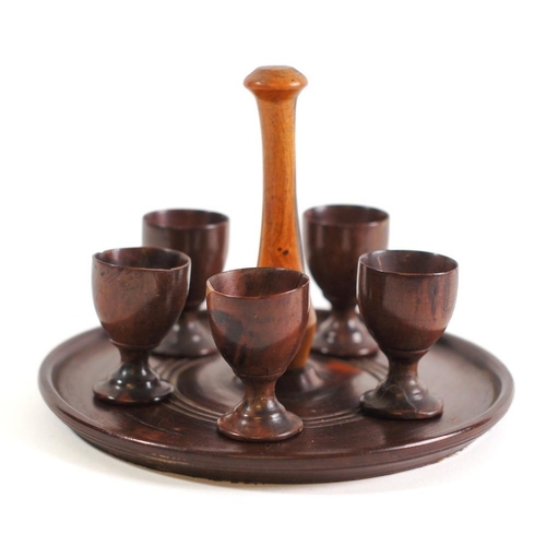 258 - A lignum vitae circular quail's egg cruet stand: with central turned handle, 18cm diameter, together... 