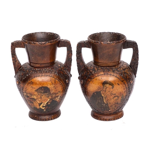 346 - A pair of carved wood twin-handled candle stands: of urn shape, with copper studded bodies and paint... 